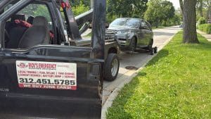Rick’s wheel-lift tow truck with a dark SUV on a residential street